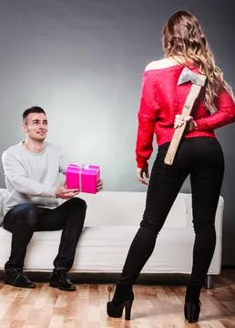 Trusting guy giving present to misleading girl Stock Photos