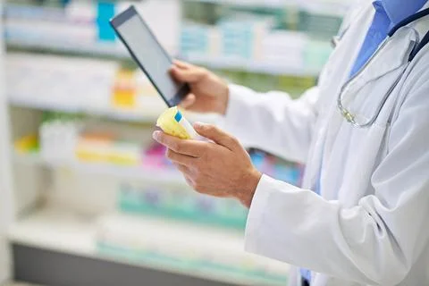 Trusting modern technology to do the thinking. A pharmacist working on a digital Stock Photos