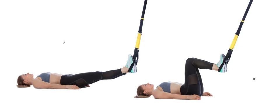 TRX hamstring curl with hips on ground Stock Photos
