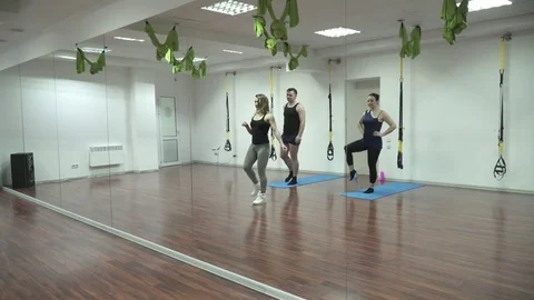 TRX trainer leads the training in front of the mirror Stock Footage 73545472