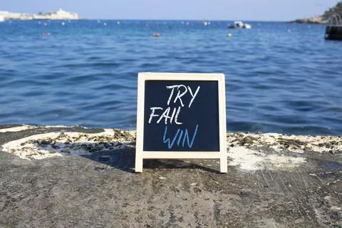 Try Fail Win symbol. Blackboard with words Try Fail Win. Beautiful sea back.. Stock Photos