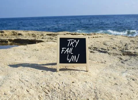 Try Fail Win symbol. Blackboard with words Try Fail Win. Beautiful sea back.. Stock Photos