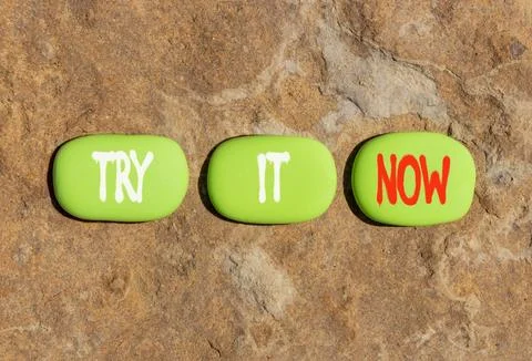 Try it now words symbol. Concept words Try is now on beautiful green stones.. Stock Photos
