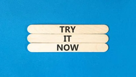 Try it now words symbol. Concept words Try is now on beautiful wooden stick.. Stock Photos