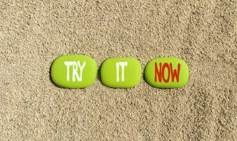 Try it now words symbol. Concept words Try is now on beautiful green stones.. Stock Photos