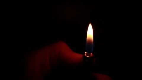 Trying to burn lighter in the darkness 動画素材 81857558