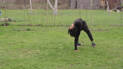 Trying cartwheel for the first time at a grass lawn Stock Footage 193118331