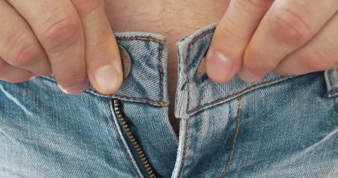 Trying on clothes in a store fitting room. Man can not button his jeans at waist Stock Footage 315217785