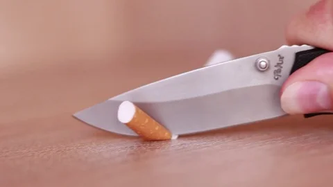 Trying to cut cigarette filter by knife 動画素材 83532959