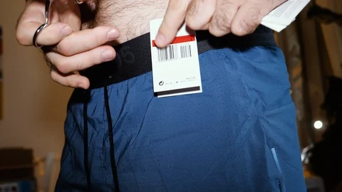 Trying cutting label of Nike Tech Pack Men's Running Shorts Stock Footage 111536351