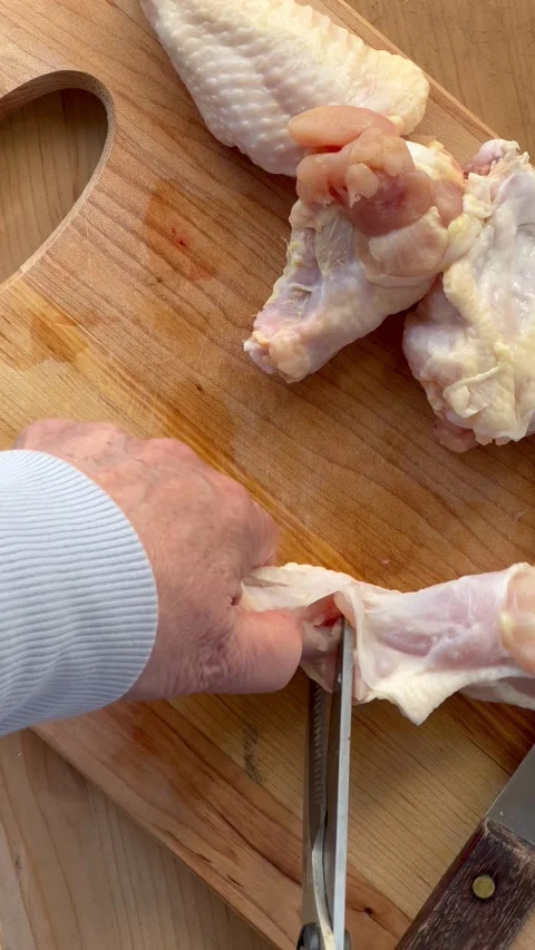 Trying to disjoint chicken wings Stock Footage 220435251