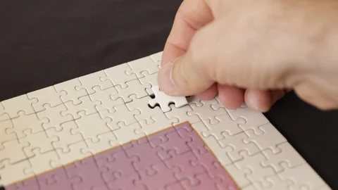 Trying to force piece into jigsaw puzzle Stock Footage 94479016