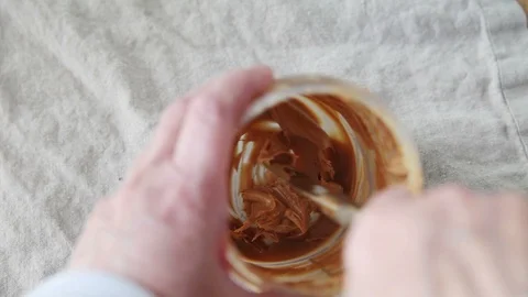 Trying to get peanut butter at jar bottom Stock Footage 108788770