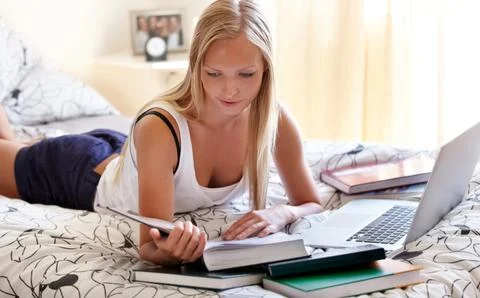 Trying to get ready for finals. Young college student working on an assignment Stock Photos