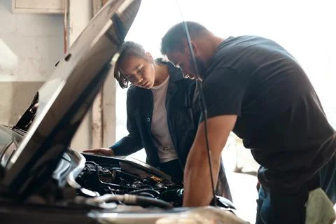 Trying to identify the source of the problem. two mechanics working together on Stock Photos