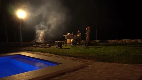 Trying to start a fire with friends at a grill chatting and having drinks in a c Vidéo 199531644