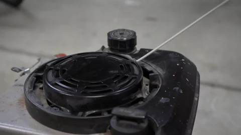Trying to start a small engine on a gas powered mower, or equipment Stock Footage 238487448