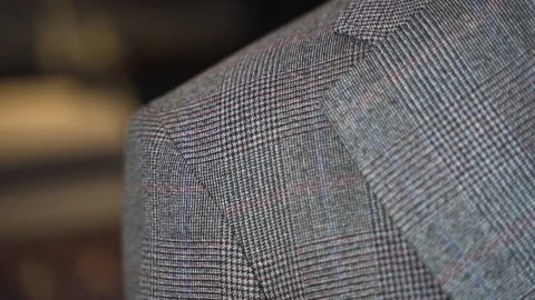 Trying thickness of grey tweed suit jacket shoulder pad, close up. Stock Footage 208083141