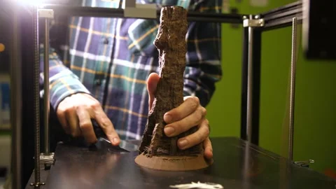 Trying very hard to remove a completed plastic model from a 3D printer Stock Footage 201226893