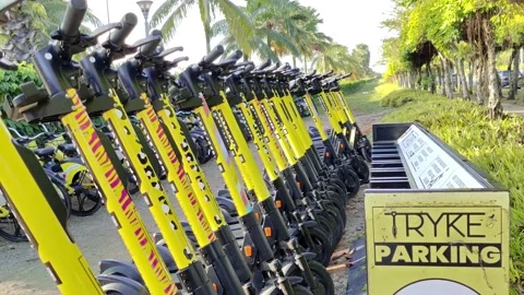 TRYKE e-scooters in the parking zone for rental at Perdana Lake, Cyberjaya. 動画素材 186025761
