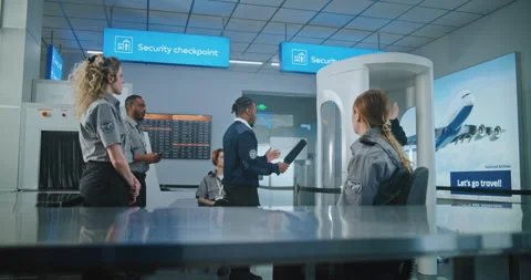 TSA Officer Demonstrating Process of Scanning Passengers with Metal Detector to Stock-Footage 306913863