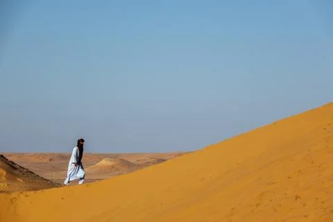 Tuareg man walking along a sand dune ridge, North Africa, Ghardaia, Algeria Stock Photos