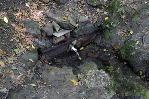 A tube inserted into the spring for convenience of a set of drinking water. S Foto stock