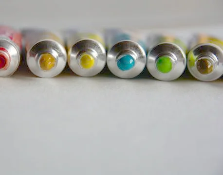 Tubes close-up with bright multi-colored watercolors blue, yellow, green shad Stock Photos