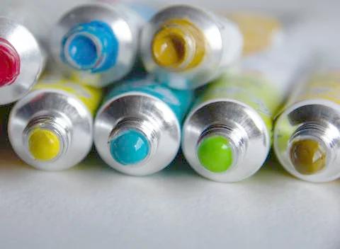 Tubes close-up with bright multi-colored watercolors blue, yellow, green shad Stock Photos