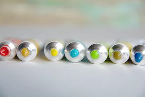 Tubes close-up with bright multi-colored watercolors blue, yellow, green shad Stock Photos