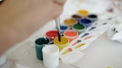 Tubes of colored paint on the table. Brush dipped in paint. Creative hobby. Video stock 115959027