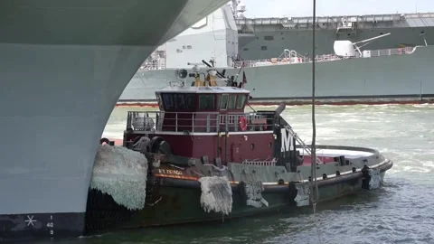 Tug boat positioned against USS Gerald R. Ford ready for departure Vidéo 240297665