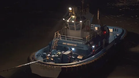 Tug boat pulling cargo ship at night - New Zealand Stock Footage 76431030