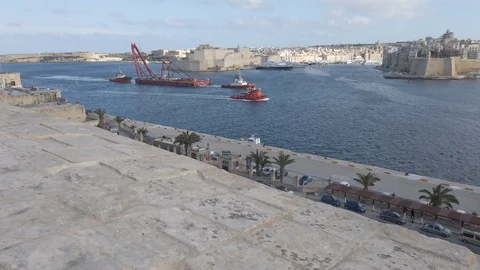Tug boats pulling crane barge in grand harbour  Valletta  Malta Aerial 4k. Stock Footage 123475373