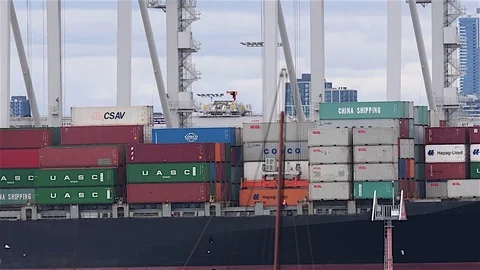 Tug passes loading container ship Stock Footage 80925731