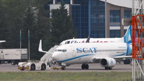 Tug pulling Boeing 737 of SCAT Airlines at Almaty airport Stock Footage 321858057