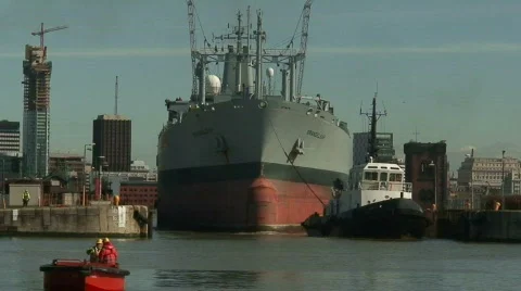 Tug pulling huge tanker into dock. HD 1080i Stock Footage 67184