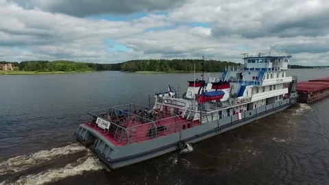 The tug pushes the barge along the river Stock Footage 83427500
