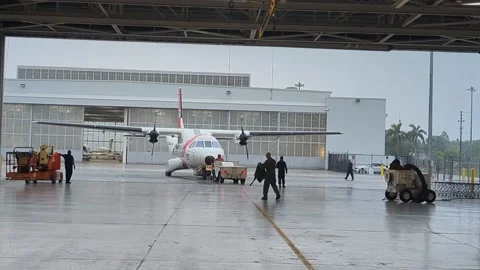 Tug pushing U.S. Coast Guard C-27J Spartan aircraft out of hangar Stock Footage 213923324