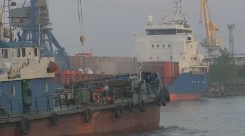 The tug sails into port by a cargo ship Stock Footage 64899412