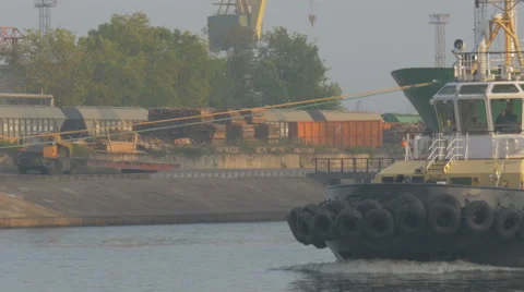 The tug sails into port by a cargo ship Stock Footage 64903302