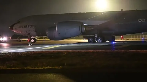 Tug towing U.S Air Force KC-135 Stratotanker at night during exercise Titan Fury Video stock 256638271