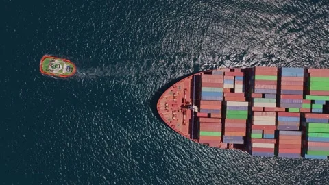 Tugboat assisting large container ship at sea aerial top view Stock Footage 336688162
