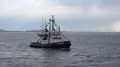 Tugboat cruising on river at Bremerhaven Germany at grey cloudy rainy day 4k or 4k+ Resolution