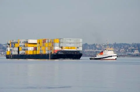 Tugboat pulling ship into dock Stock Photos