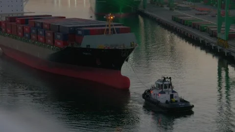 Tugboat towing large cargo container ship in harbor channel Vidéo 337690732