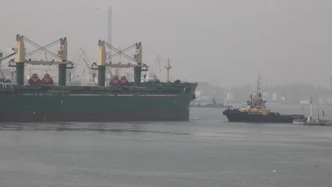 Tugboats help to deploy a dry cargo ship in the port. Stock Footage 88158708