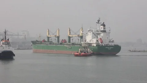 Tugboats help to deploy a dry cargo ship in the port. Stock Footage 88158713