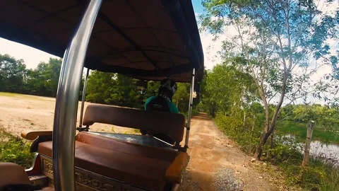 A Tuk Tuk driver is driving through the countryside of Cambodia near Kampot Stock Footage 100772574
