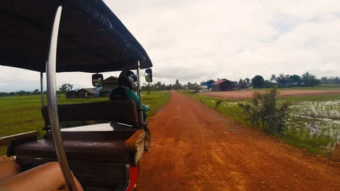 A Tuk Tuk driver is driving through the countryside of Cambodia near Kampot Stock Footage 100786147